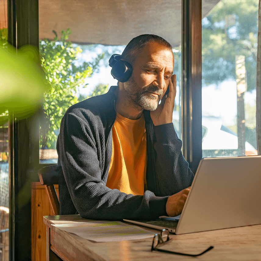 Man Wearing Headphones and Focusing on Laptop