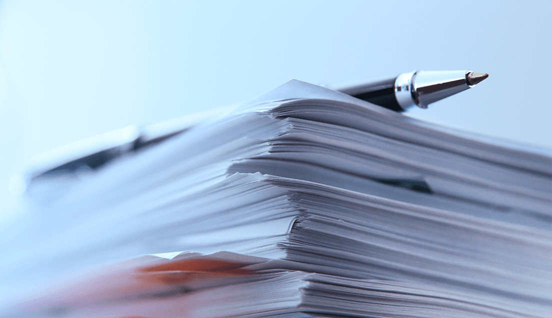 Pen Sitting on Top of Stacked Papers