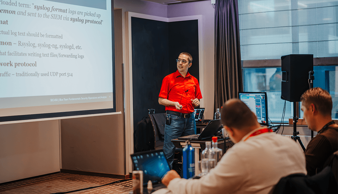 Teacher In Red Shirt Reviewing Content On Large Screen