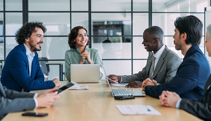 People Sitting Around Conference Table and Smiling