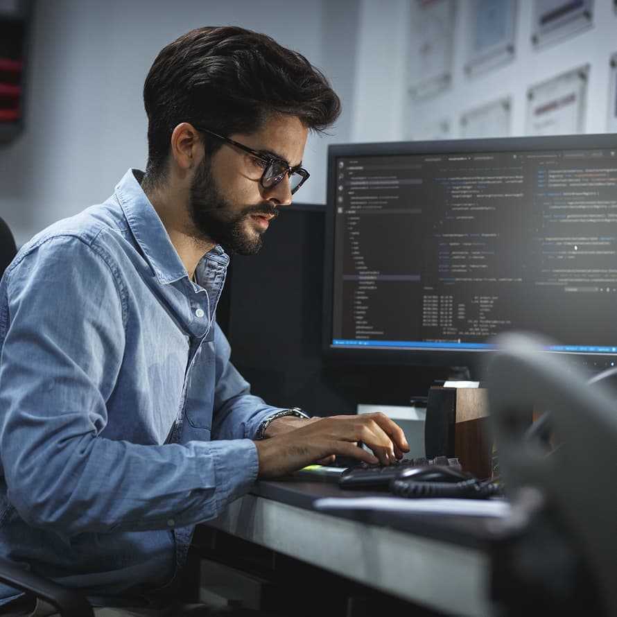 Man in Blue Shirt and Glasses Typing on Keyboard