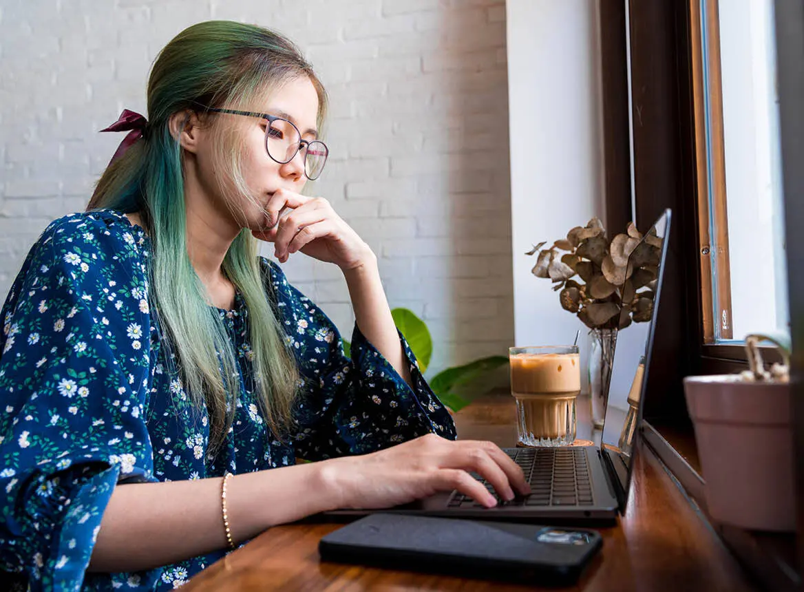 Woman Sitting at Laptop With Coffee: REDI